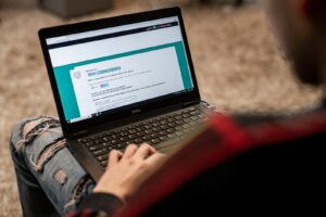 a person sitting on the floor using a laptop